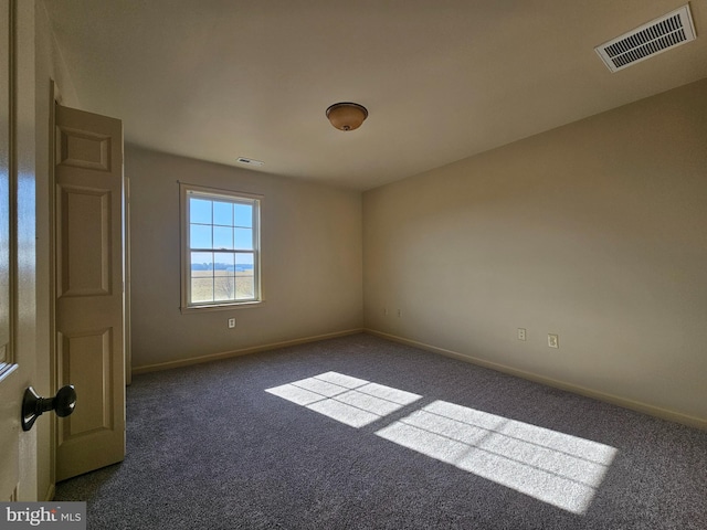 spare room with dark carpet