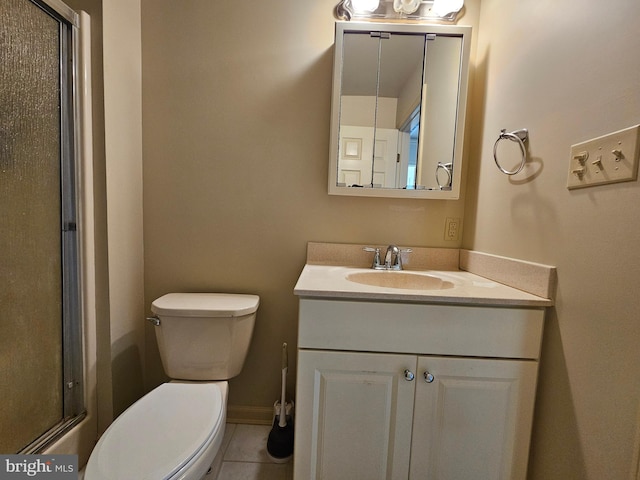 bathroom with tile patterned flooring, vanity, toilet, and a shower with door