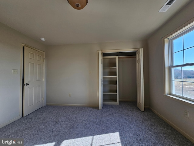 unfurnished bedroom featuring carpet flooring, a closet, and multiple windows