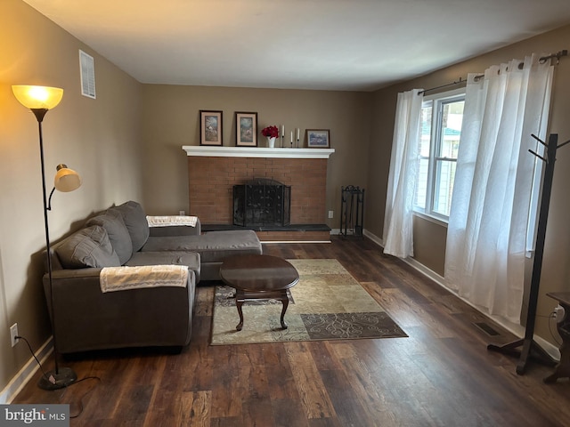 living room with dark hardwood / wood-style floors and a brick fireplace