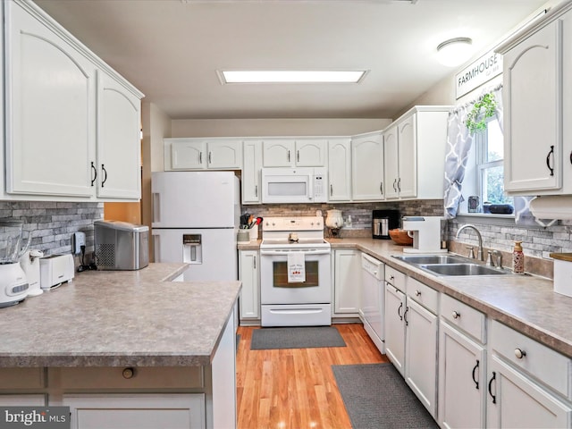 kitchen featuring white appliances, white cabinetry, and sink