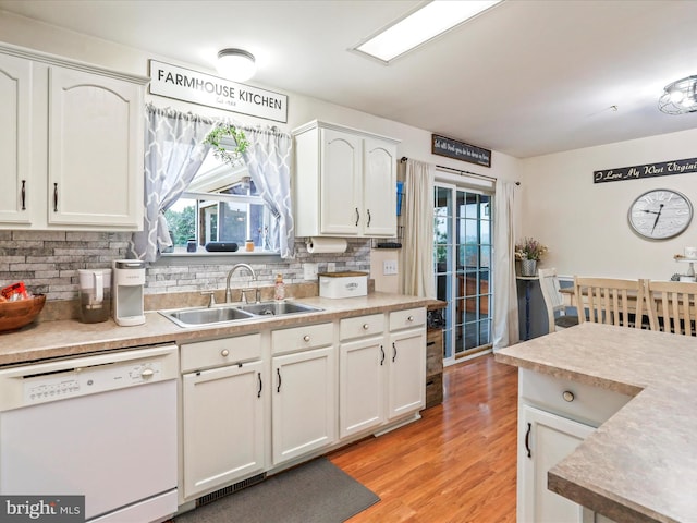 kitchen featuring sink, light hardwood / wood-style flooring, backsplash, white cabinetry, and dishwasher