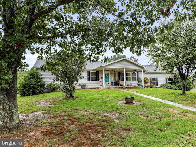 view of front of property featuring ceiling fan, a front yard, and an outdoor fire pit