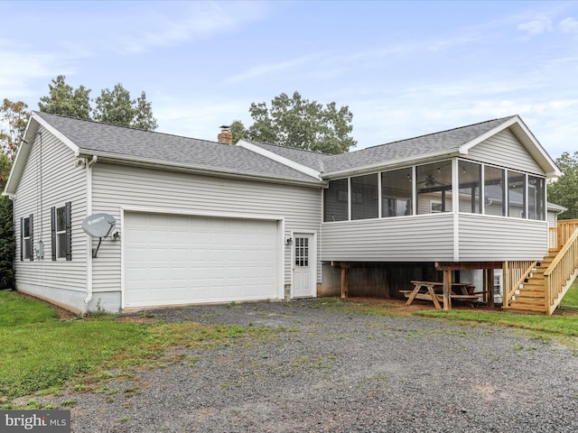 view of front of property featuring a garage and a sunroom