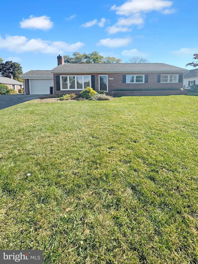 single story home featuring a garage and a front lawn