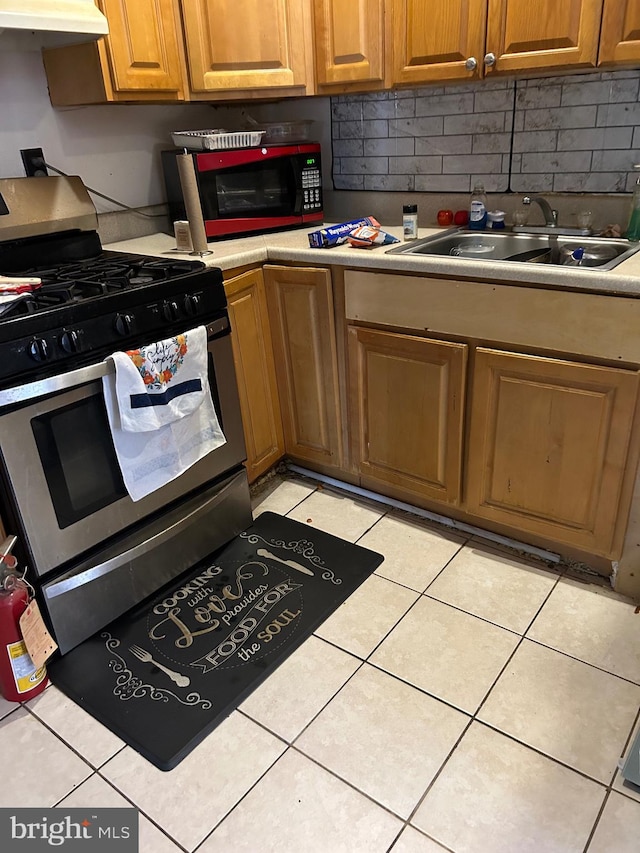 kitchen with sink, decorative backsplash, stainless steel gas stove, light tile patterned floors, and extractor fan