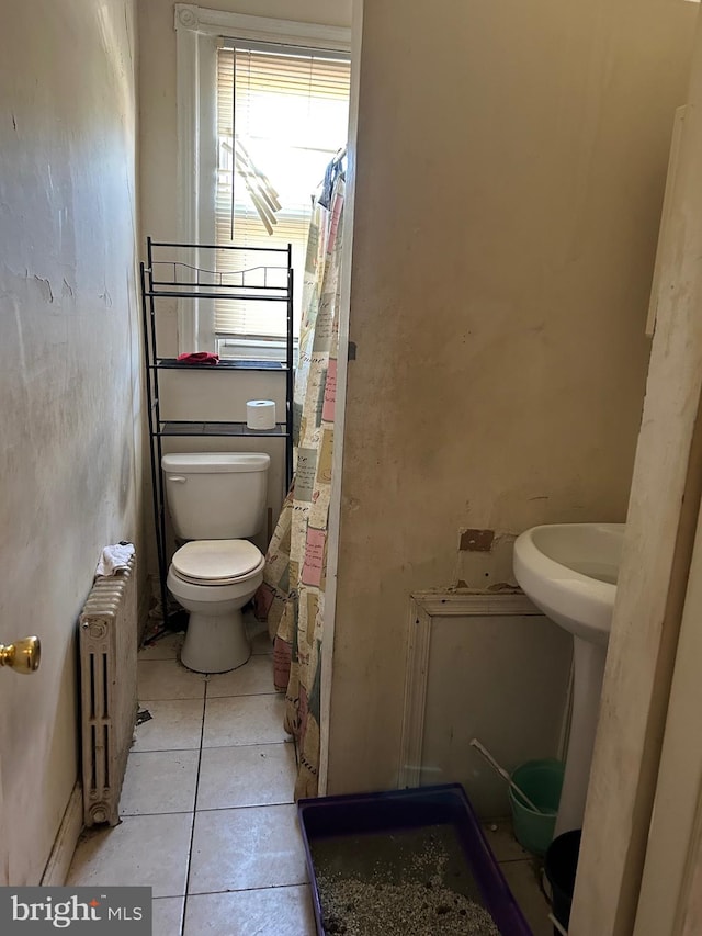 bathroom with a shower with curtain, radiator, toilet, and tile patterned floors