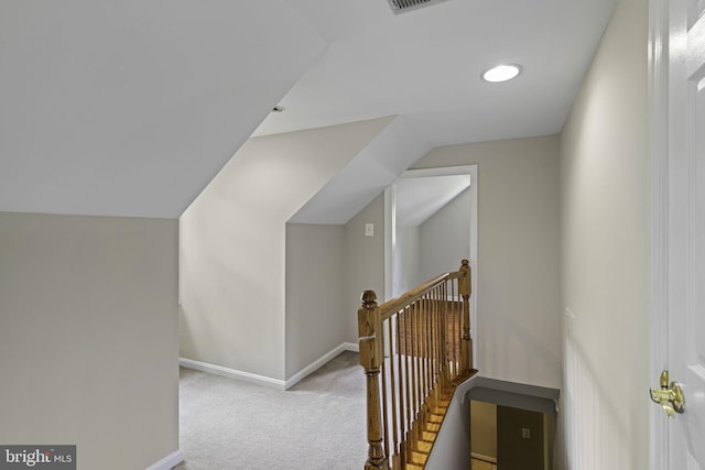 hall with baseboards, light carpet, vaulted ceiling, and an upstairs landing