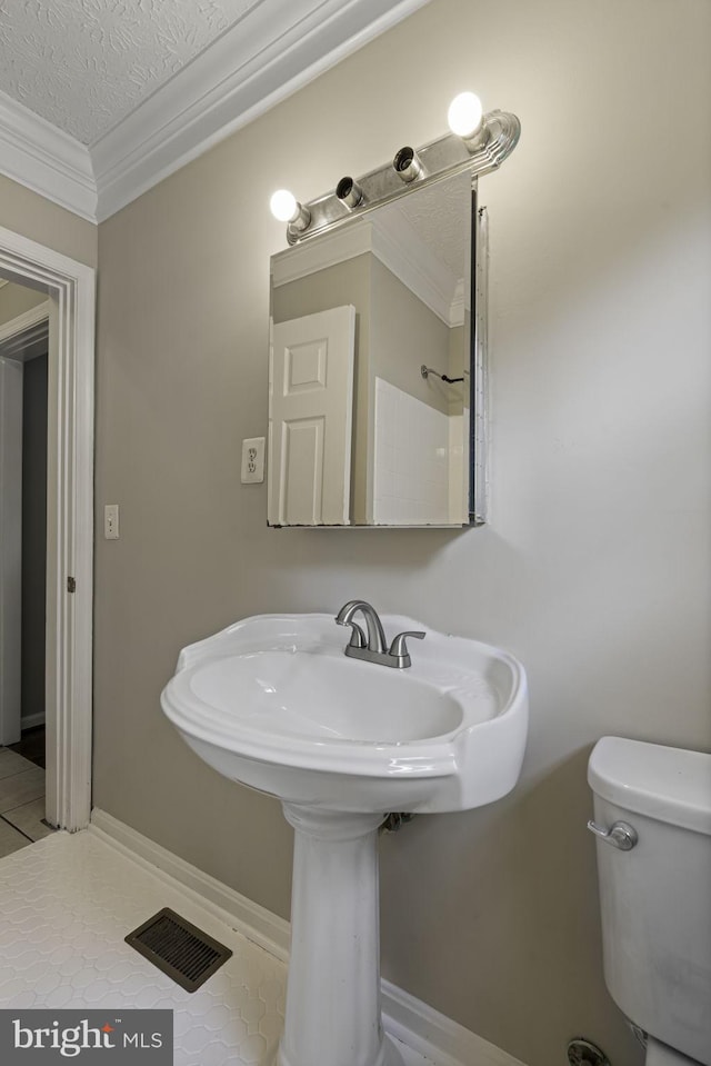 bathroom with visible vents, toilet, tile patterned floors, a textured ceiling, and crown molding