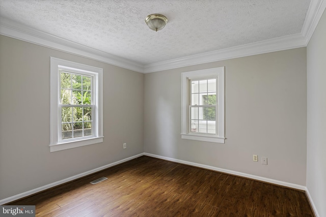 spare room with ornamental molding, dark wood-type flooring, visible vents, and baseboards