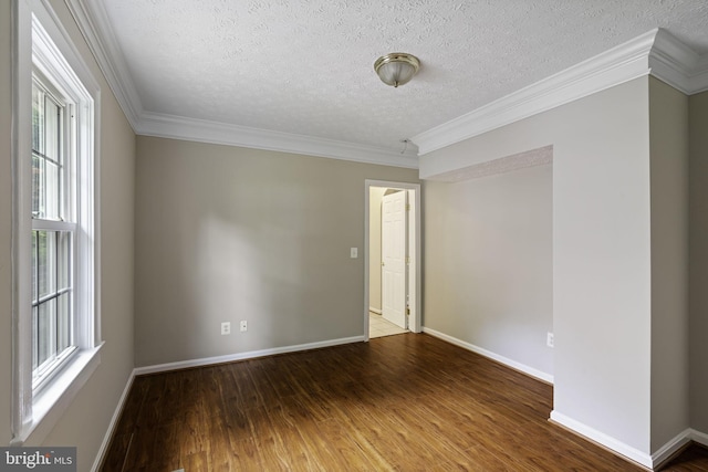 unfurnished room featuring baseboards, a textured ceiling, ornamental molding, and wood finished floors