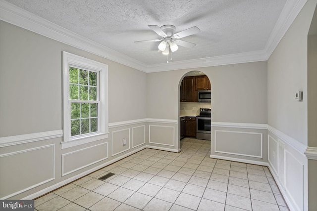 empty room featuring light tile patterned floors, visible vents, arched walkways, ceiling fan, and a decorative wall