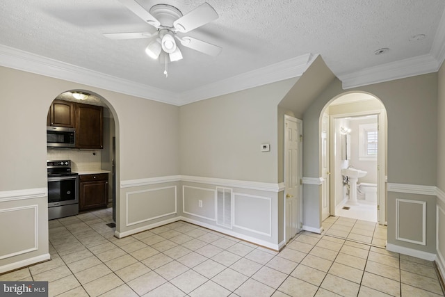 empty room with arched walkways, ceiling fan, light tile patterned flooring, a decorative wall, and visible vents