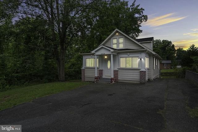 bungalow with aphalt driveway and brick siding