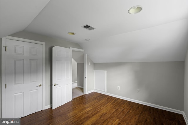 additional living space featuring visible vents, vaulted ceiling, baseboards, and wood finished floors