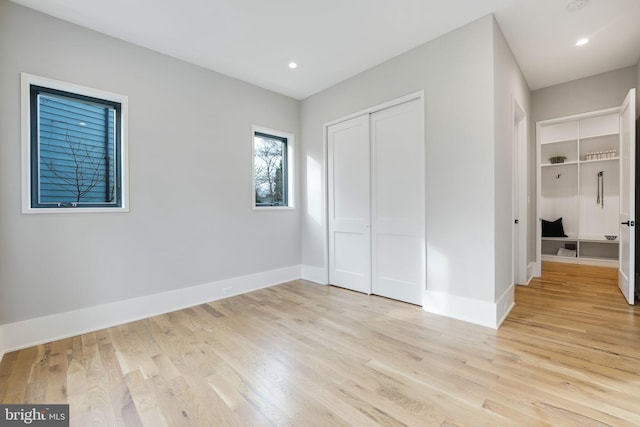 unfurnished bedroom with light hardwood / wood-style floors and a closet