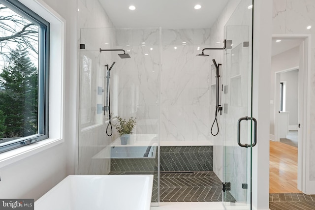 bathroom with independent shower and bath and hardwood / wood-style flooring