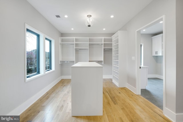 walk in closet with light wood-type flooring