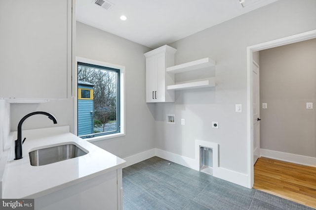 clothes washing area with cabinets, hookup for an electric dryer, washer hookup, dark hardwood / wood-style floors, and sink