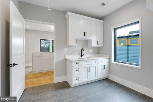 kitchen with white cabinets, dark wood-type flooring, and sink