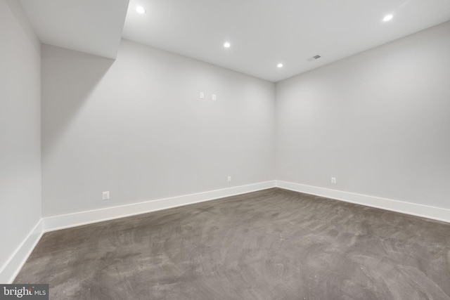 unfurnished room featuring dark colored carpet