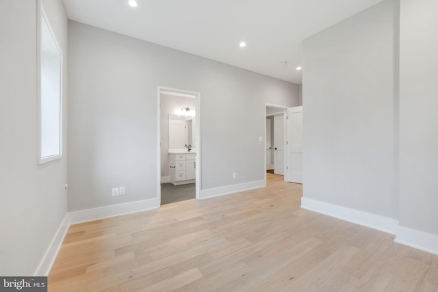 unfurnished bedroom featuring light hardwood / wood-style floors and ensuite bath