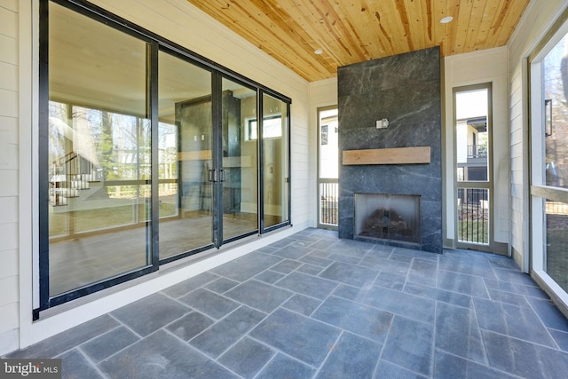 exterior space with wood ceiling and a fireplace