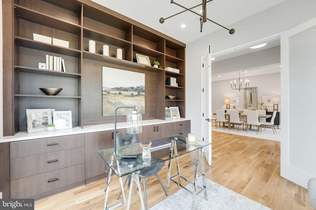 home office featuring light hardwood / wood-style flooring and an inviting chandelier