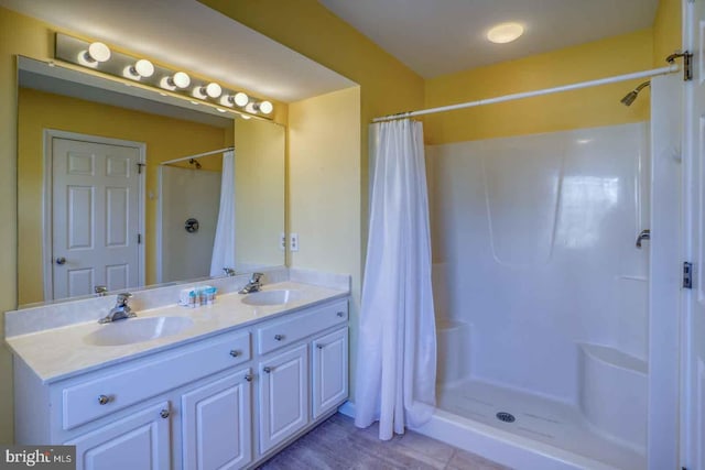 bathroom featuring walk in shower and vanity