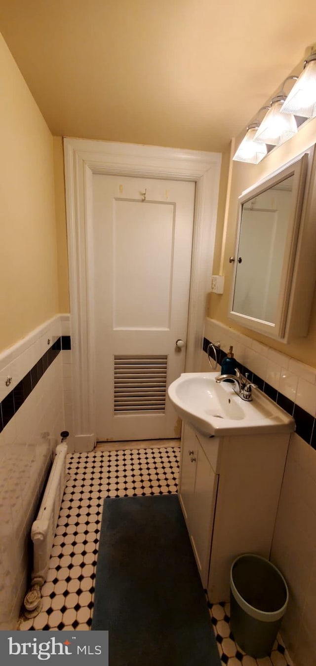 bathroom with tile walls, vanity, and tile patterned floors