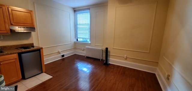 kitchen with radiator heating unit and dark hardwood / wood-style flooring