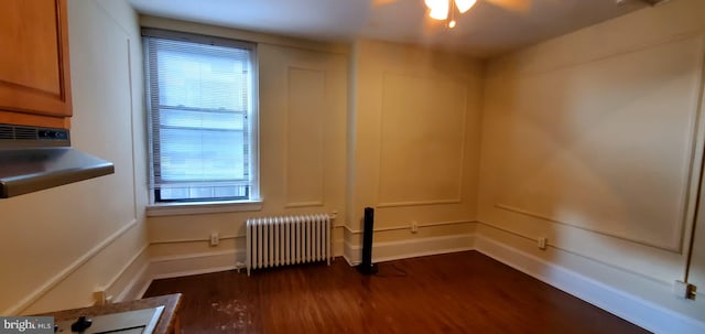 interior space featuring dark wood-type flooring and radiator heating unit