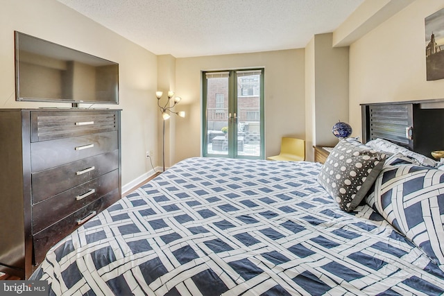 bedroom with french doors and a textured ceiling