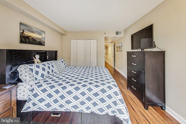 bedroom with wood-type flooring and a closet