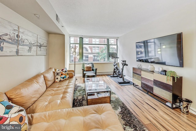 living room featuring wood-type flooring, a textured ceiling, and a baseboard radiator