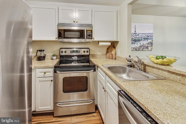 kitchen featuring light wood-type flooring, white cabinetry, sink, and stainless steel appliances