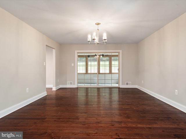 unfurnished room featuring dark hardwood / wood-style floors and a chandelier