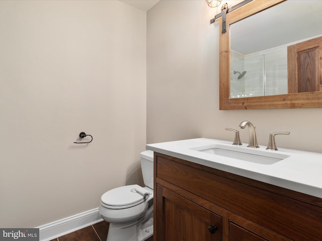 bathroom with tiled shower, vanity, tile patterned flooring, and toilet