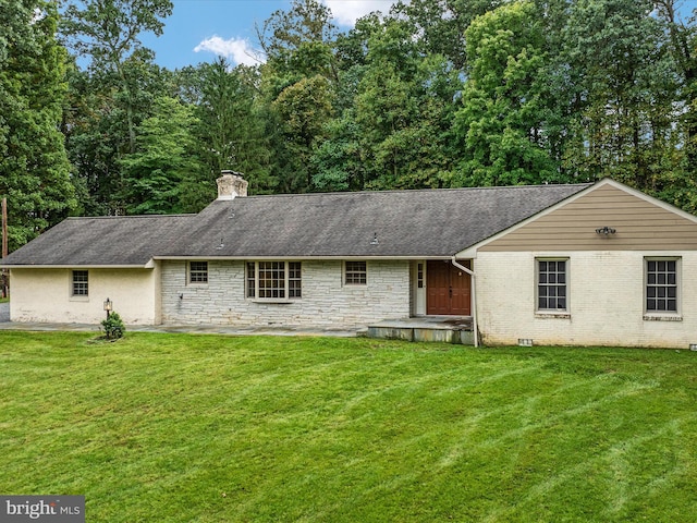 back of house featuring a patio area and a lawn