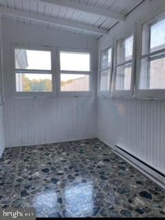 unfurnished sunroom with wooden ceiling, beamed ceiling, and plenty of natural light