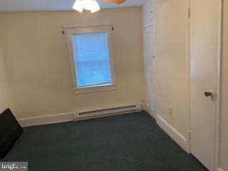 unfurnished room with ceiling fan and a baseboard radiator