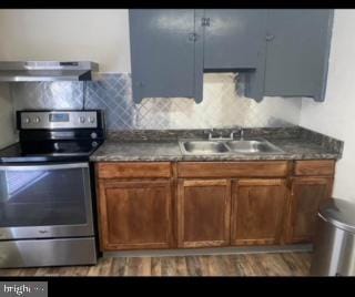 kitchen featuring decorative backsplash, sink, stainless steel electric stove, and extractor fan