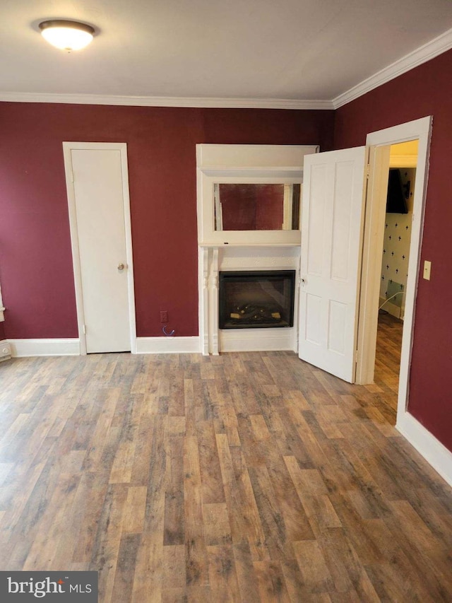 unfurnished living room featuring ornamental molding and dark hardwood / wood-style flooring