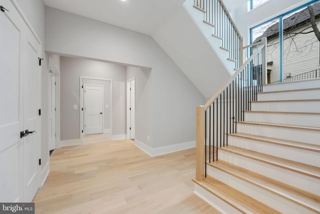 stairway featuring hardwood / wood-style flooring and vaulted ceiling