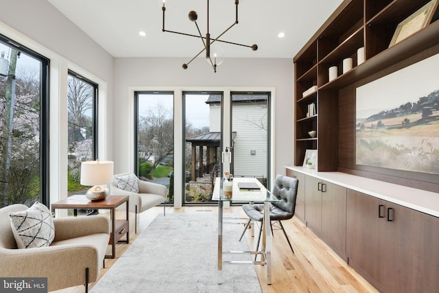 living area with light hardwood / wood-style floors and a chandelier