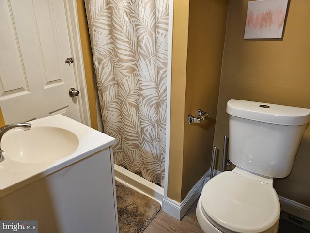 bathroom with a shower with shower curtain, wood-type flooring, vanity, and toilet