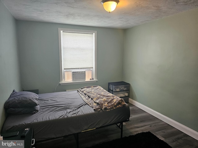 bedroom featuring a textured ceiling, cooling unit, and dark hardwood / wood-style floors