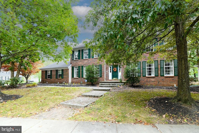 colonial house featuring a front yard