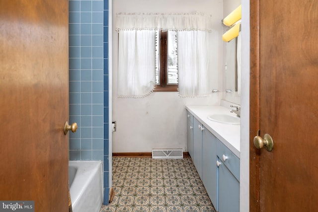 bathroom with a washtub and vanity