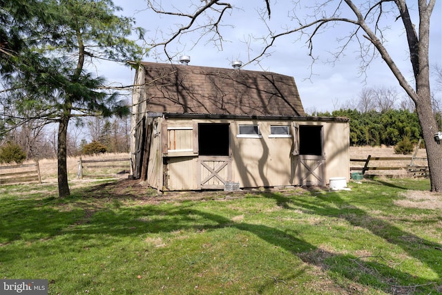 view of outbuilding featuring a rural view and a yard